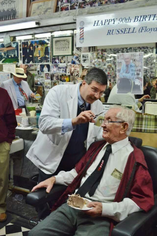 Floyd giving real barber, Russell Hiatt, a trim at his 90th birthday celebration in Mt. Airy, NC.