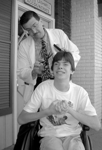 Floyd trimming up Kyle's hair on the streets of Mayberry Days.